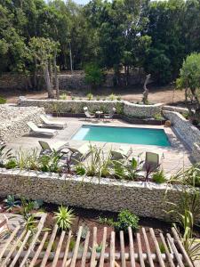a swimming pool in a garden with a stone wall at Maison Mahana in Bonifacio +65 photos
