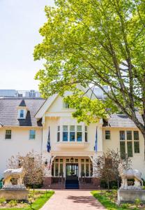 a house with two statues in front of it at The Inn at Stonecliffe in Mackinac Island