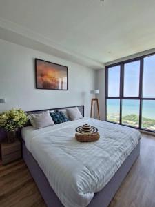 Un dormitorio con una cama grande con una cesta. en Best Sea View Amazing 2 Bed Room-Mesmerizing Views, en Pattaya South 47 fotos más