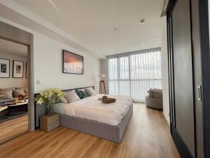 Un dormitorio con una cama grande y una sala de estar. en Best Sea View Amazing 2 Bed Room-Mesmerizing Views, en Pattaya South