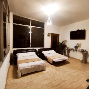 ein Wohnzimmer mit zwei Betten und einer Couch in der Unterkunft Quinta Vacacional Oasis en Pedro Vicente Maldonado-Pichincha Ecuador in Pedro Vicente Maldonado