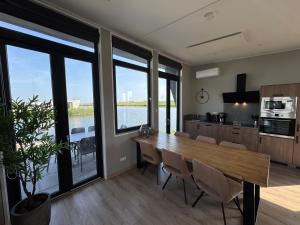 una cucina e una sala da pranzo con un grande tavolo in legno di De IJssel Eilanden Chalet Laguna Kampen mit Zaun Nr 754 a Kampen