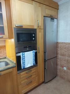 a kitchen with a stainless steel refrigerator and a microwave at Apartamento 2 habitaciones con garaje in Gondomar