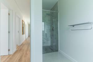 a glass shower in a white room with a hallway at Sapphire Sands by Atlantic Holiday in Estreito da Calheta +45 photos