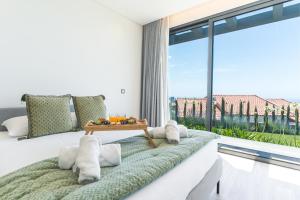 a bedroom with a bed and a large window at Sapphire Sands by Atlantic Holiday in Estreito da Calheta