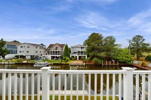 ベサニービーチにあるTown of South Bethany --- 308 W 6th Stの家屋が並ぶ川の横の白い柵