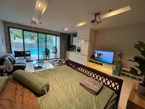 北芭堤雅Beachfront Luxe with Pool Access and Terrace的带沙发和电视的客厅