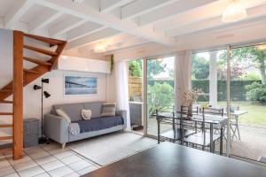 a living room with a couch and a table at Proche lac : Maison avec beau jardin in Biscarrosse