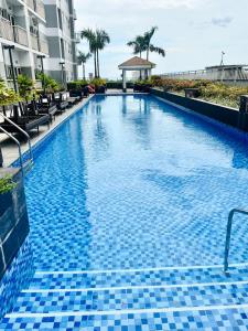 a swimming pool with blue tiles on the side of a building at Stunning Suite with Balcony near MOA in Manila
