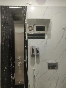 Un baño con una pared de mármol blanco con ventilador. en Modern, Stylish & Luxurious 1 BHK stay,22, en Bhubaneshwar 7 fotos más