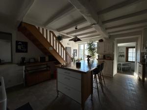 a kitchen with a counter top and a staircase at Chambre à la campagne - salle d'eau individuelle in Saint-Aubin-le-Cloud