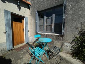 a table and chairs sitting outside of a building with a door at Chambre à la campagne - salle d'eau individuelle in Saint-Aubin-le-Cloud