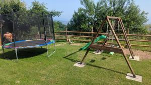 einen Spielplatz mit Schaukel und Trampolin in der Unterkunft Domaine de la Griffe - Appartement "Sous Dine" in La Roche-sur-Foron