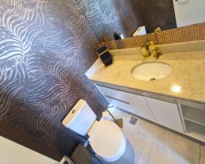 un bagno con lavandino, WC e specchio di BookSantos Unlimited 905 Duplex com Linda Vista Mar a Santos