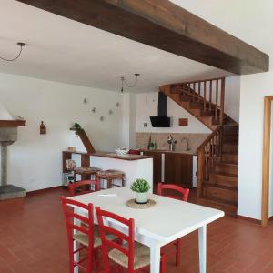 a dining room with a white table and red chairs at Dama35 - Tuscany holiday house - Casentino-La Verna in La Verna