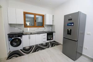 a kitchen with a washing machine and a refrigerator at Era e Liqenit in Shkodër