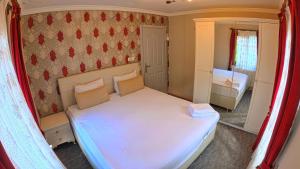 Dormitorio pequeño con cama blanca y espejo en Nil Pansiyon, en Uzungöl