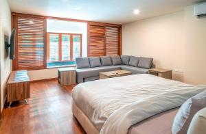 ein Schlafzimmer mit einem Bett und einer Couch und einem Fenster in der Unterkunft Luxury 3 Bedroom Condo - Infinity Pool - AWA Residences - Condo Anahuac 110 in Playa del Carmen