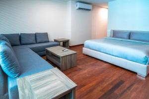 ein Wohnzimmer mit einer Couch, einem Bett und einem Tisch in der Unterkunft Luxury 3 Bedroom Condo - Infinity Pool - AWA Residences - Condo Anahuac 110 in Playa del Carmen