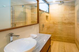 ein Badezimmer mit Waschbecken und Dusche in der Unterkunft Luxury 3 Bedroom Condo - Infinity Pool - AWA Residences - Condo Anahuac 110 in Playa del Carmen