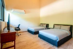 ein Zimmer mit zwei Betten, einem Schreibtisch und einem Fernseher in der Unterkunft Luxury 3 Bedroom Condo - Infinity Pool - AWA Residences - Condo Anahuac 110 in Playa del Carmen + 19 Fotos