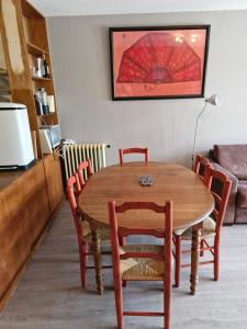 オルシエールにあるAppartement au pied des pistes avec vue sur la montagneの赤い傘が付いたダイニングテーブルと椅子