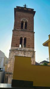 a tall brick tower with a cross on top of it at La Casa del Don in Capua