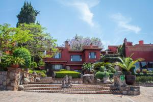 a large red house with stairs in front of it at Villa Montaña Hotel & Spa in Morelia