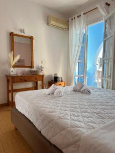 a bedroom with a bed with a mirror and a window at Celeste NAXOS Chora in Naxos Chora