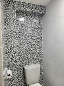 un bagno con wc e parete piastrellata di Casa do aconchego cohab1 a Garanhuns Altre 15 foto