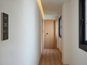 a hallway with white walls and a door at Nur City Suites in Athens