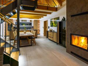 a living room with a fireplace and a dining area at Lipno - Luxury Lake Villa in Nové Domky