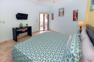 a bedroom with a bed and a tv in it at Beachfront Condo, 2 BR - Ocean View at Corto Maltes in Playa del Carmen