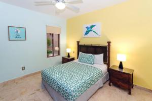 a bedroom with a bed and two lamps and a ceiling fan at Beachfront Condo, 2 BR - Ocean View at Corto Maltes in Playa del Carmen