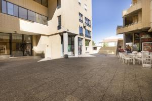an empty street in front of a building with tables and chairs at LV Premier Marques MQ2 in Porto