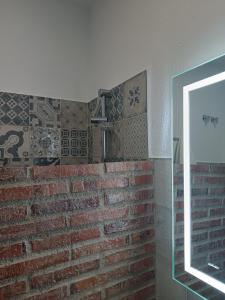 a room with a brick wall and a mirror at La Troje Pensión in Lucainena de las Torres