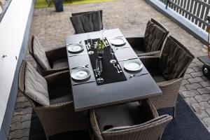 a black table with chairs and a table set for a meal at Julchen's Landhaus in Oberlahr
