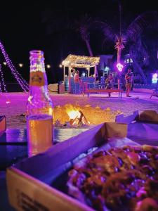 Una botella de cerveza y una caja de comida en la playa. en Barefoot Beach Belize, en Caye Caulker 37 fotos más