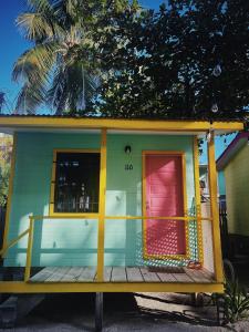 a house with a colorful door and a deck at Barefoot Beach Belize in Caye Caulker