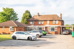 three cars parked in a parking lot in front of a house at The Watling Inn in Nuneaton