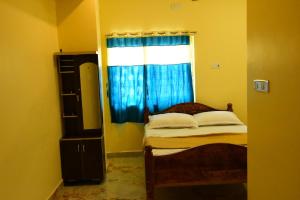 a small bedroom with a bed with a window at Shree Varahi Residency in Tiruvannāmalai