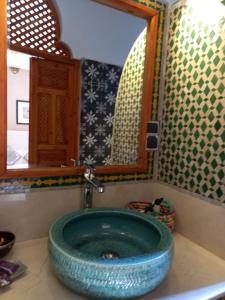 une salle de bain avec un grand lavabo bleu avec un miroir dans l'établissement Riad Ouarzazate, à Ouarzazate