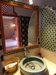 a bathroom with a sink in front of a mirror at Riad Ouarzazate in Ouarzazate +68 photos