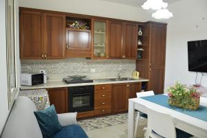 a kitchen with wooden cabinets and a table with a dining room at A Casuzza in Salemi