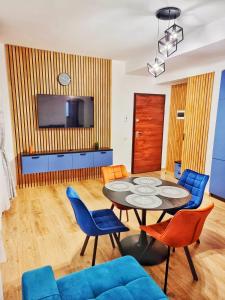 a living room with a table and chairs and a television at Alpin Confort Predeal in Predeal