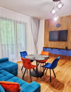 a living room with a blue couch and a table and chairs at Alpin Confort Predeal in Predeal
