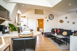a kitchen and living room with a couch and a table at Le Ballanais - Parking - Netflix in Ballan-Miré