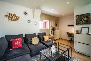 a living room with a black couch and a table at Le Ballanais - Parking - Netflix in Ballan-Miré