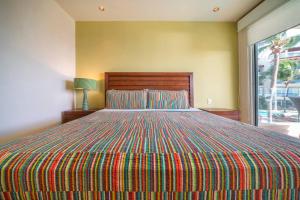 Un dormitorio con una cama con una manta colorida. en Ocean View Condo - 2 Bedrooms - at The Elements Condos - Castillo de Arena, en Playa del Carmen