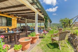 an outdoor patio with tables and chairs and plants at Tra Cielo e Mare Rooms Rio Marina in Rio nellʼElba